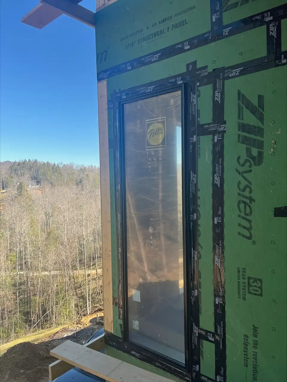 Window set in taped wall sheathing with a ridge view behind it