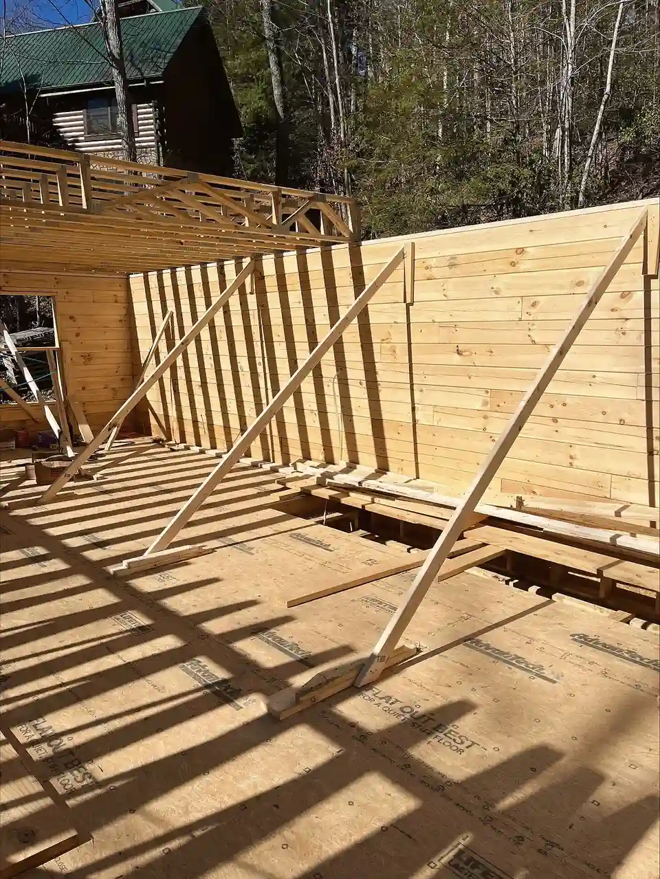 Builder & Subcontractor Coordination: framed wall panels braced on a new subfloor deck